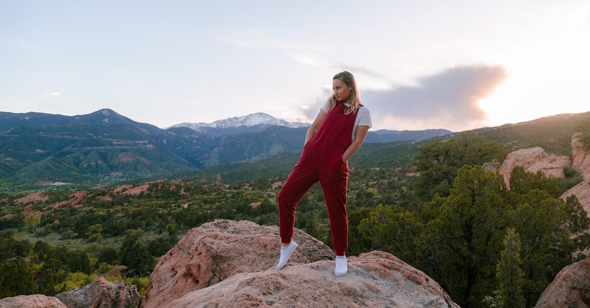 A person wearing red Swoveralls outdoors in the mountains